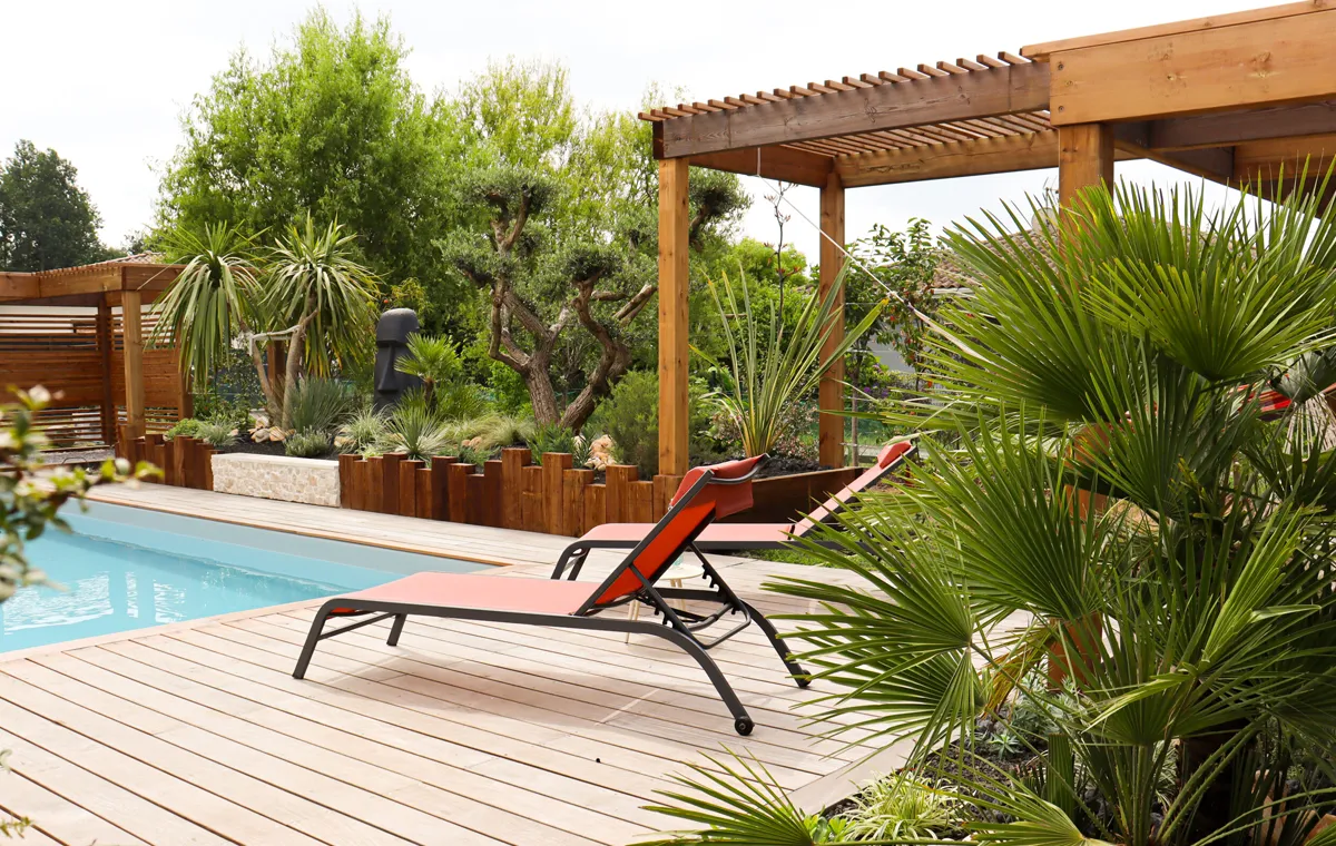 Terrasse en bois au bord d'une piscine et pergolas en bois - paysagiste Gironde