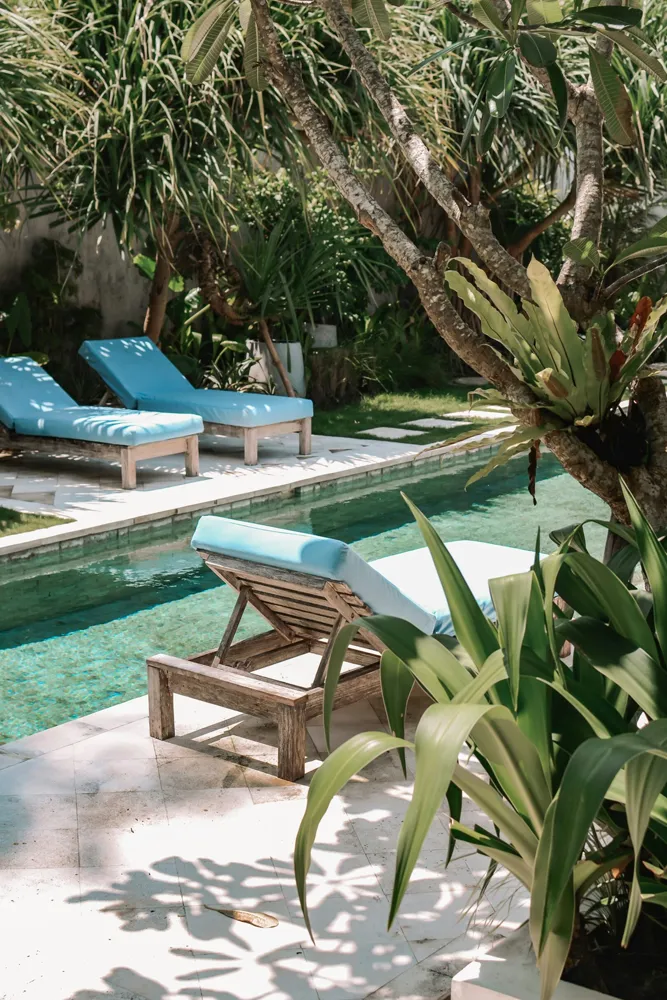 Paysagiste à Andernos-les-Bains — Bord de piscine paysager avec palmier sur une terrasse carrelage en pierres naturelles — Jardin à la Carte