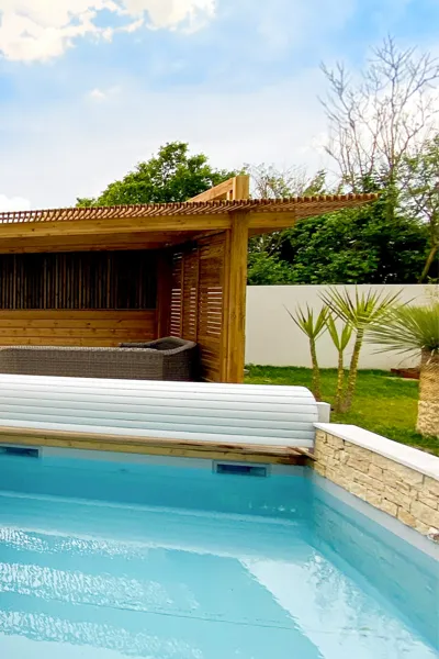 Pergola en bois sur-mesure pour salon de jardin et maçonnerie piscine